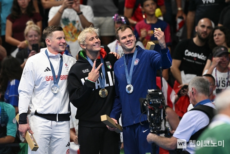 (왼쪽부터) 2024 파리 올림픽 수영 남자 평영 100m 시상식에서 애덤 피티(Adam Peaty, 영국), 니콜로 마르티넨기(Nicolo Martinenghi, 이탈리아), 닉 핑크(Nic Fink, 미국) 선수가 빅토리 셀피를 찍고 있는 모습 / 2024.09.12 (출처: 삼성전자)