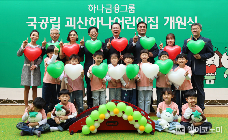 하나금융그룹은 지난 11일 충청북도 괴산군과 함께 민관 협력으로 건립한 『국공립 괴산하나어린이집』을 개원했다. 하나금융그룹은 아이 키우기 좋은 환경을 조성해 저출생 문제를 해결하고자 2018년부터 ‘100호 어린이집 건립 프로젝트’를 진행 중이며, 이번 97번째 『국공립 괴산하나어린이집』이 개원으로 ‘100호 어린이집 건립 프로젝트’ 성료에 한걸음 다가서게 됐다. 이날 개원식에 참석한 강성묵 하나금융그룹 부회장(맨 뒷줄 왼쪽에서 네 번째)이 송인헌 괴산군수(맨 뒷줄 왼쪽에서 다섯 번째)와 어린이집 원장, 학부모, 어린이, 내외빈들과 함께 97번째 어린이집 개원을 축하하며 기념촬영을 하고 있다. / 2024.10.13 (출처: 하나금융그룹)
