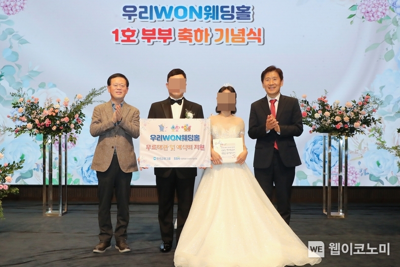 지난 13일 취약계층 신혼부부의 결혼식을 위해 우리금융 본사 사옥 웨딩홀을 무료로 대관해 주는 ‘우리 WON 웨딩홀’ 1호 부부가 탄생했다. (왼쪽부터) 조병규 우리은행장, ‘우리 WON 웨딩홀’ 1호 부부, 김현훈 서울특별시사회복지협의회장이 기념촬영을 하고 있다. / 2024.10.14 (출처: 우리금융그룹)