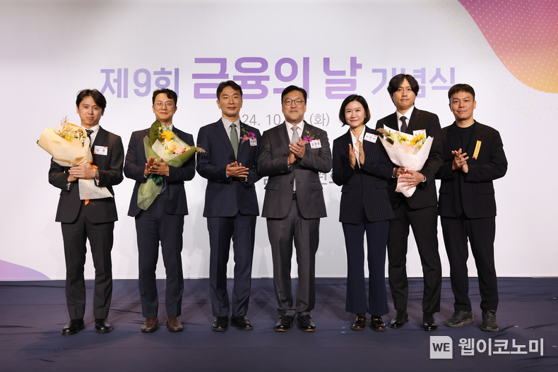제9회 금융의 날을 맞아 총 3개 부문에서 대통령 표창 등을 수상한 토스뱅크 대표와 임직원들이 활짝 웃으며 박수 치고 있다. 왼쪽부터 김준 토스뱅크 신용여신 트라이브 리더, 이정하 토스뱅크 정보보호최고책임자, 이복현 금융감독원장, 김병환 금융위원장, 이은미 토스뱅크 대표, 송관석 토스뱅크 수신 트라이브 리더. / 2024.10.29 (출처: 토스뱅크)