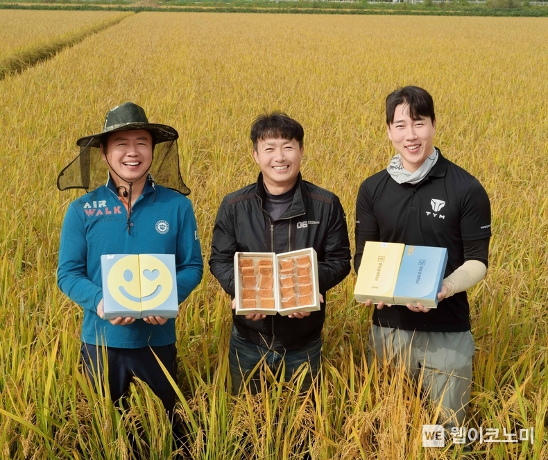 경기도 평택시에 위치한 가루쌀 농가에서 농업인들이 가루쌀을 원료로 활용한 파리바게뜨의 샌드쿠키를 들고 기념 촬영을 하고 있다. / 2024.11.07 (출처: SPC그룹)