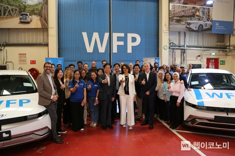 (맨 앞줄 왼쪽에서 다섯번째부터) 현대자동차 이항수 전무, 사라 아담 WFP 정부공여국장, 스티븐 앤더슨 WFP 중동권역본부장을 비롯한 WFP 차량기지 직원들이 아이오닉 5와 함께 기념사진을 촬영하는 모습. / 2024.11.15 (출처: 현대차·기아)