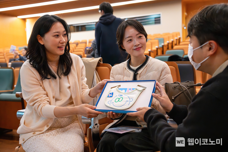 지난 22일 오후 광화문 교보생명 본사 23층 대산홀에서 열린 ‘찾아가는 음악회’에 참석한 임산부들이 스마일 턱받이를 건네 받고 있다. / 2024.11.25 (출처: 교보생명)