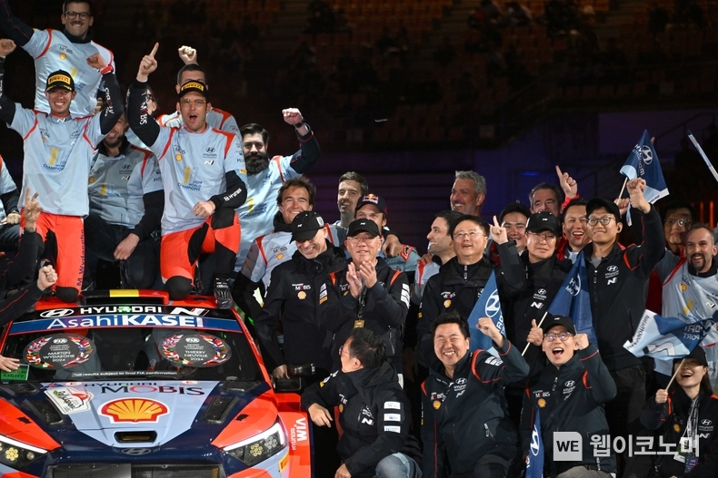 정의선 현대차그룹 회장이 24일(일) WRC 일본 랠리 후 드라이버 우승을 차지한 티에리 누빌(차 위 앞 줄 오른쪽) 선수 및 임직원들과 기념촬영을 하는 모습 / 2024.11.25 (출처: 현대차·기아)