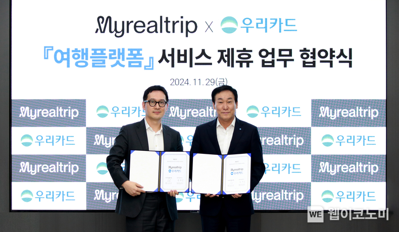 지난달 29일 우리카드 광화문 본사에서 박완식 우리카드 대표이사(오른쪽)와 이동건 마이리얼트립 대표이사가 업무 협약을 진행하고 기념사진을 촬영하고 있다. / 2024.12.03 (출처: 우리카드)