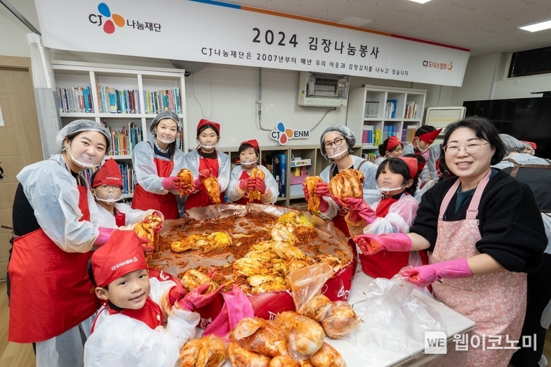 지난 6일 서울시 망원무지개지역아동센터에서 진행된 ‘2024 CJ 김장 나눔’ 봉사에서 CJ임직원 봉사자와 지역아동센터 아이들이 직접 만든 김치를 들어보이고 있다. / 2024.12.11 (출처: CJ)