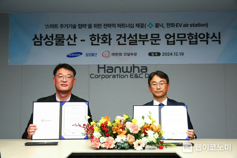 ㈜한화 건설부문 김민석 건축사업본부장(좌측)과 삼성물산 박민용 개발사업본부장(우측)이 스마트 주거기술 협력을 위한 전략적 파트너십 체결하고 기념촬영을 하고 있다. / 2024.12.19 (출처: 한화 건설부문)