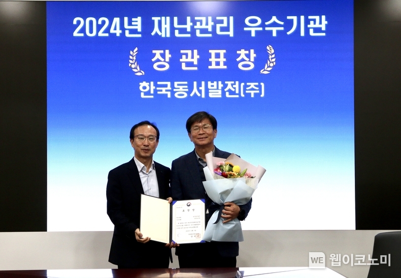 이정우 동서발전 안전보건처장(오른쪽)과 김현진 산업부 산업재난담당관 과장(왼쪽)이 '2024년 재난관리 우수기관' 장관표창장을 들고 기념사진을 촬영하는 모습. / 2024.12.20 (출처: 동서발전)