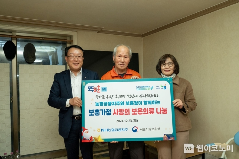 농협금융은 23일, 서울지방보훈청과 함께 국가유공자 및 보훈가정에 사랑의 보온의류 나눔을 실시했다. 박종국 NH농협금융지주 이사회 사무국장(왼쪽), 이은주 서울지방보훈청 복지과장(오른쪽) 및 보훈가정 어르신이 기념촬영을 하고 있다. / 2024.12.24 (출처: NH농협금융)
