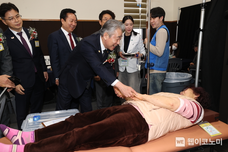 강호동 농협중앙회장이 환자용 침대에 누워있는 농업인의 손을 따뜻하게 맞잡고 있다. 2025.02.25 (출처: 농협중앙회)