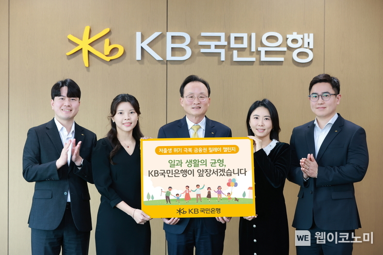 서울시 영등포구에 위치한 KB국민은행 신관에서 이환주 KB국민은행장(가운데)과 ‘KB아이사랑적금’를 기획한 KB국민은행 수신상품부 직원들이 '저출생 위기 극복 챌린지'에 참여해 기념 촬영을 하고 있다. / 2025.02.26 (출처: KB국민은행)