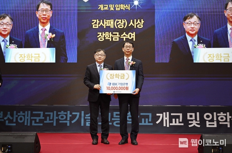 사진은 지난 4일 부산해군과학기술고등학교에서 열린 개교식에서 유일광 IBK기업은행 개인고객그룹 부행장(왼쪽)이 정인식 부산해군과학기술고등학교 교장(오른쪽)에게 장학금을 전달하고 기념촬영을 하고 있는 모습 / 2025.03.05 (출처: IBK기업은행)