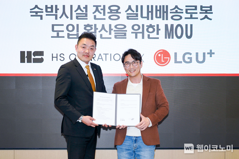 LG유플러스는 숙박시설 위탁운영 기업 HS오퍼레이션과 손잡고 아늑호텔에 실내 배송로봇을 공급한다고 17일 밝혔다. 사진은 권태혁 HS오퍼레이션 대표(왼쪽)와 박재강 LG유플러스 기업파트너담당이 실내 배송로봇 업무협약을 체결한 뒤 기념촬영을 하고 있는 모습. / 2025.03.17 (출처: LG유플러스)