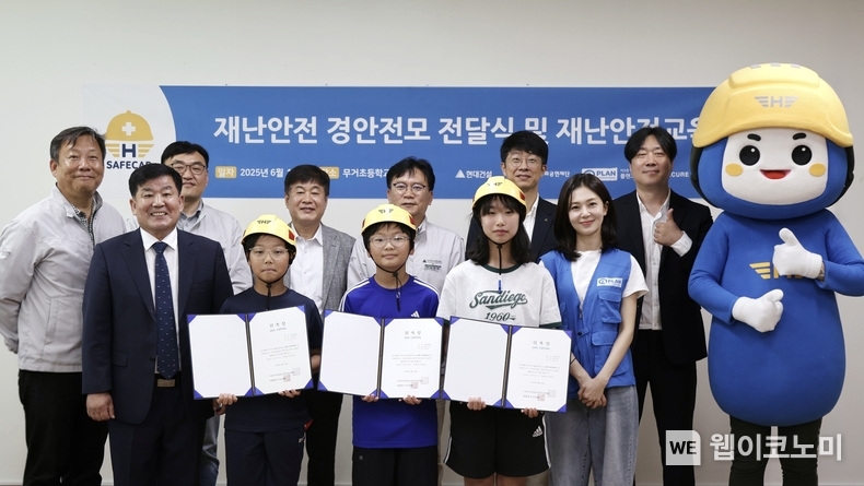 (뒷줄 왼쪽에서 3번째부터)건설산업사회공헌재단 이재식 사무처장, 현대건설 이현영 실장, 현대건설 김진홍 실장, 플랜코리아 이재명 실장과 (앞줄 왼쪽)무거초등학교 정우규 교장이 '재난안전교육 및 어린이용 경안전모 전달식' 행사 사진을 촬영하고 있다. (출처: 현대건설) / 2025. 06. 19