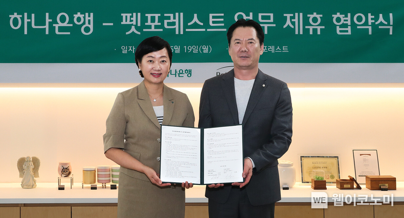 하나은행은 지난 5월 19일 반려동물 장례서비스 제공 업체인 (주)펫포레스트와 수신 VIP 손님 지원을 위한 업무협약을 체결했다. 이날 협약식에 참석한 이은정 하나은행 하나더넥스트본부장(사진 왼쪽)이 이상흥 펫포레스트 대표(사진 오른쪽)와 함께 협약서를 들고 기념 촬영을 하고 있다. (출처: 하나은행) / 2025.06.20