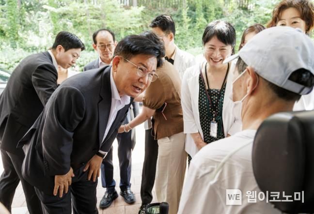 박강수 마포구청장이 휠체어를 탄 어르신의 안부를 살피고 있다.